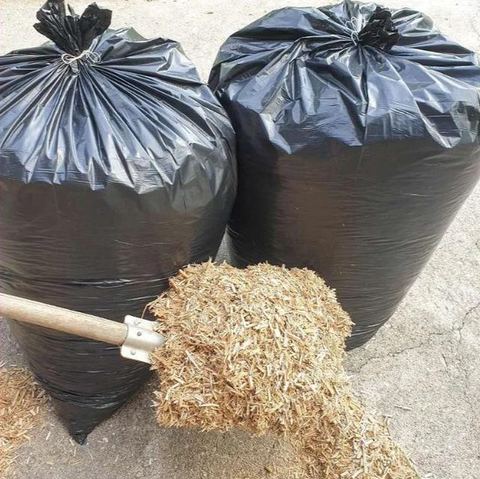 240-Liter-Säcke mit Elefantengras und eine Schaufel voll Häcksel